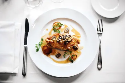 Grilled chicken on a plate with cutlery.