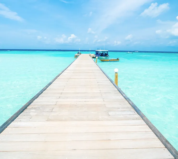 A wooden pier over clear turquoise water.