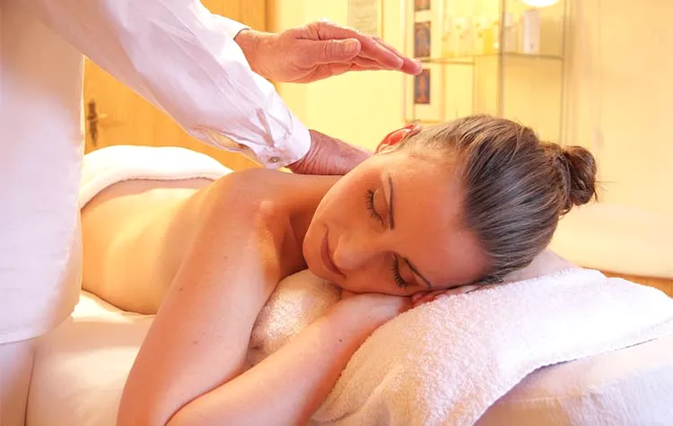 A woman resting during a back massage in a warm spa room.